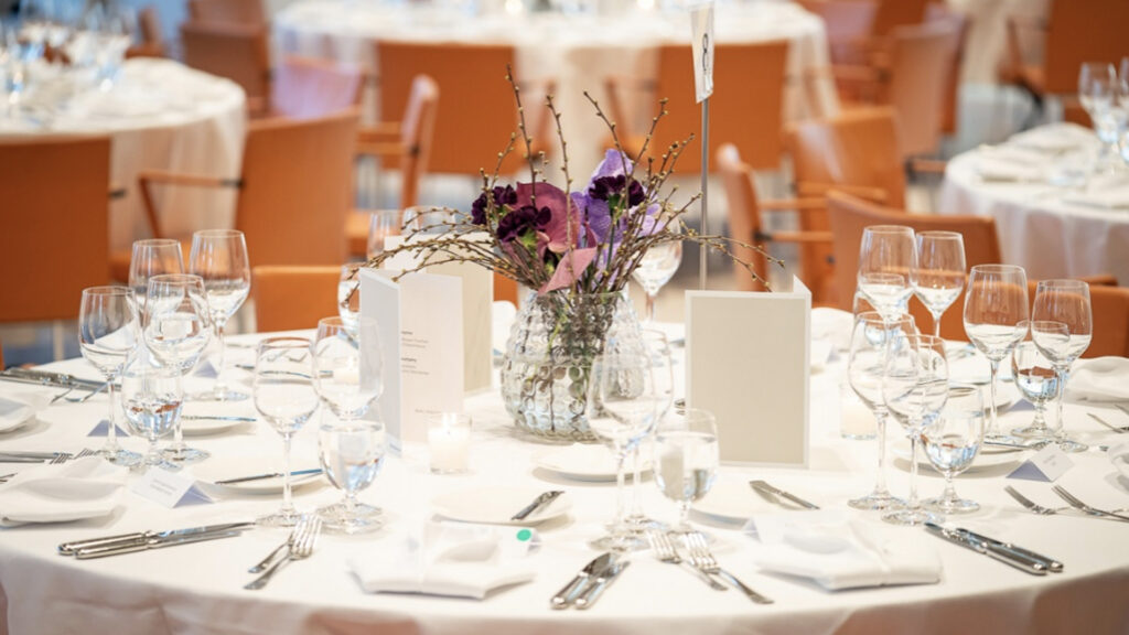 disq awardverleihung mit essen festlich gedeckter tisch mit weinglaesern und blumen