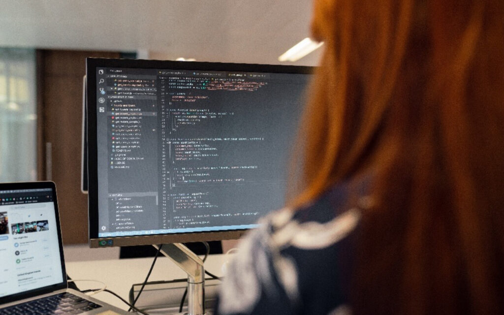 it ingenieurin sitzt vor bildschirm